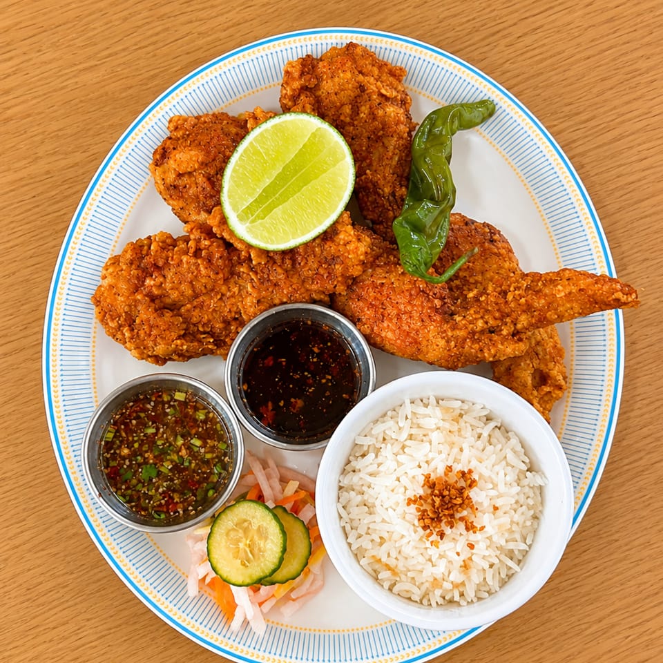Crispy fried chicken wings with lime, green pepper, two sauces, rice, and pickled vegetables.